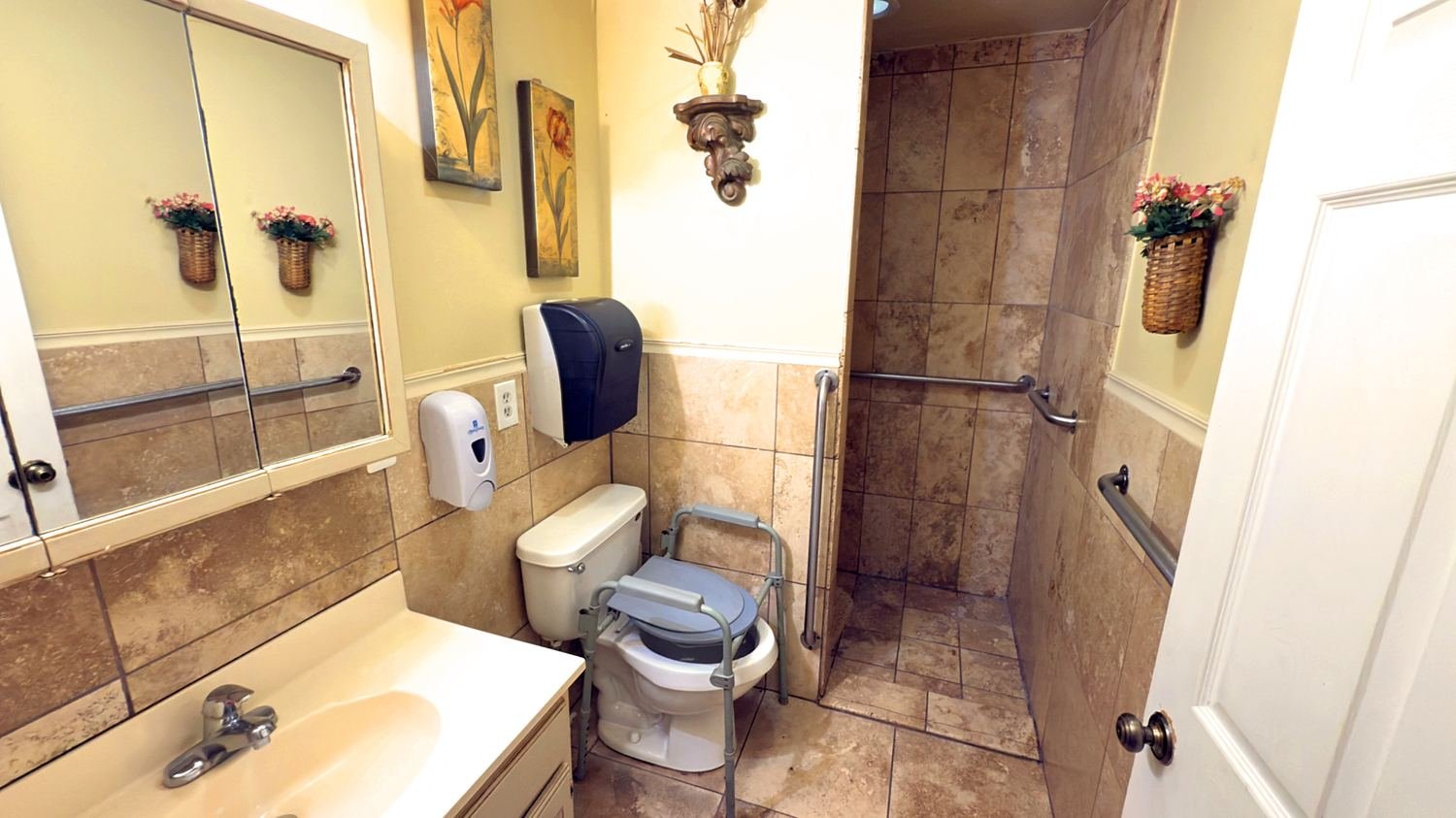 Accessible bathroom with walk-in shower and commode frame